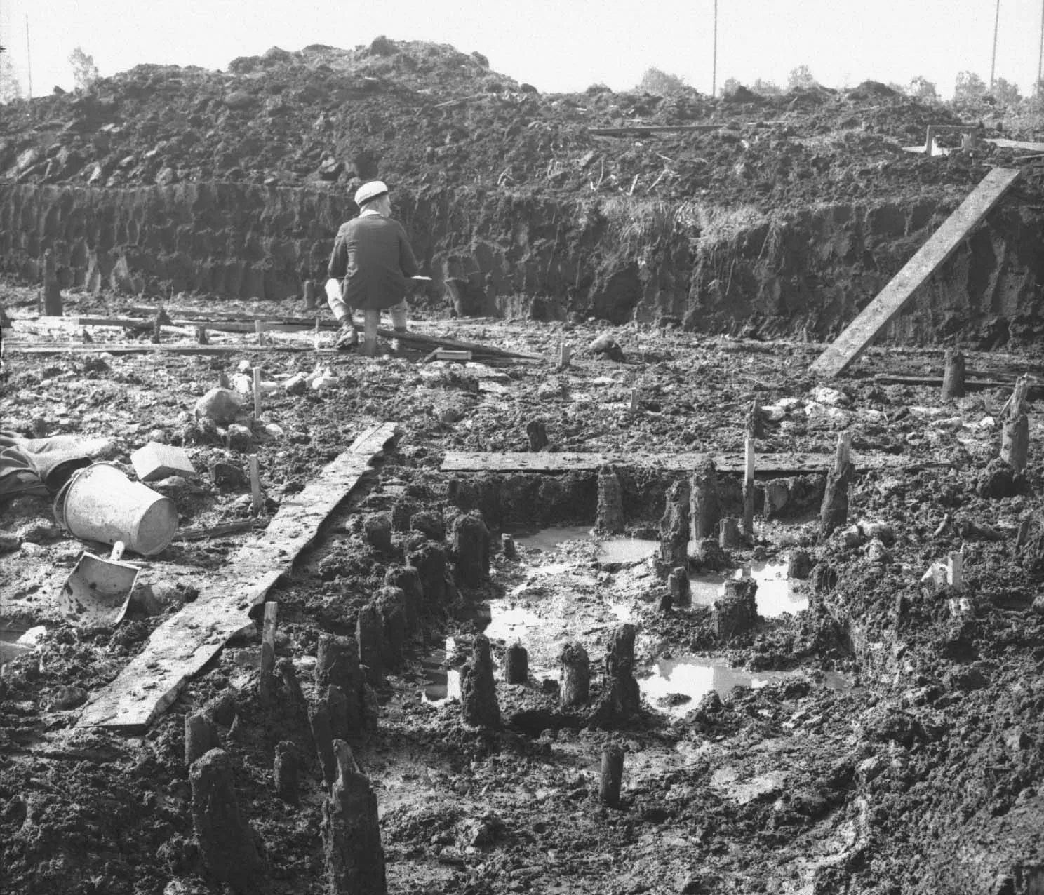 Black and white photo of person in excavation pit