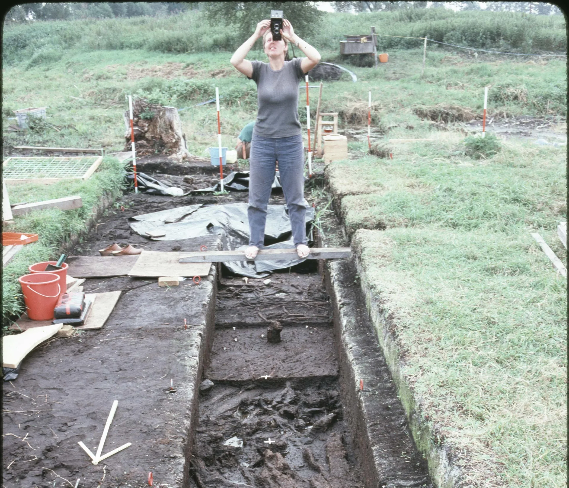 an archaeologist taking a photo on a digging sitte